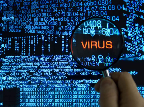 Лупа над словом Virus на фоне программного кода